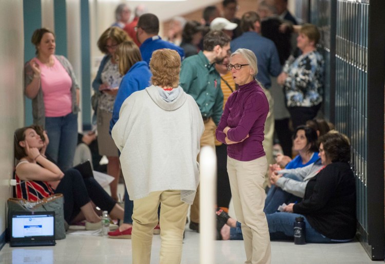 People gather in the hall Thursday during an executive session at a School Administrative District 49 school board meeting at Lawrence junior High School in Fairfield.