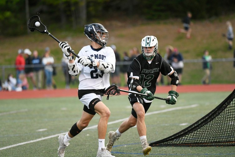 Anders Corey of Yarmouth looks for an open teammate as Luca Antolini of Waynflete moves in Friday night during Yarmouth’s 12-5 victory in boys’ lacrosse to end the regular season.
