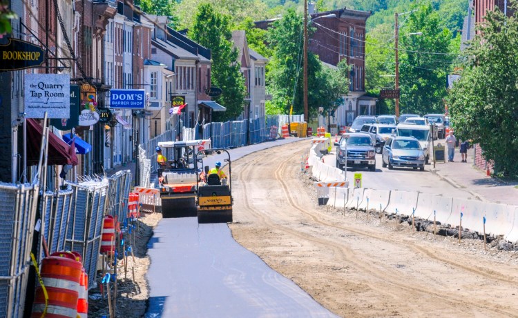 A pair of rollers move along June 13, 2018, flattening the just-paved east side of Water Street in downtown Hallowell.