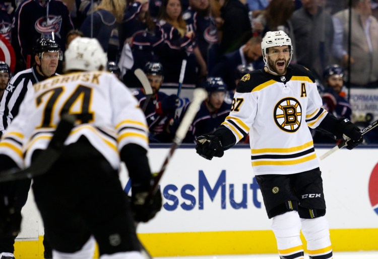 Patrice Bergeron, right, celebrates the first of his two power-play goals Thursday night against the Columbus Blue Jackets.