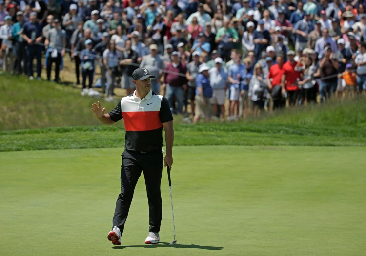 Brooks Koepka reacts after sinking a putt for birdie on the fifth green during the first round of the PGA Championship golf tournament Thursday at Bethpage Black in Farmingdale, N.Y.