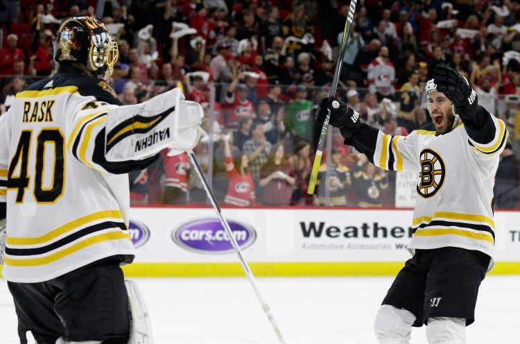 Bruins goalie Tuukka Rask celebrates with John Moore at the end of Game 4 of the NHL Eastern Conference finals against the Carolina Hurricanes in Raleigh, N.C., on Thursday night. Boston won 4-0 to advance to the Stanley Cup Final.