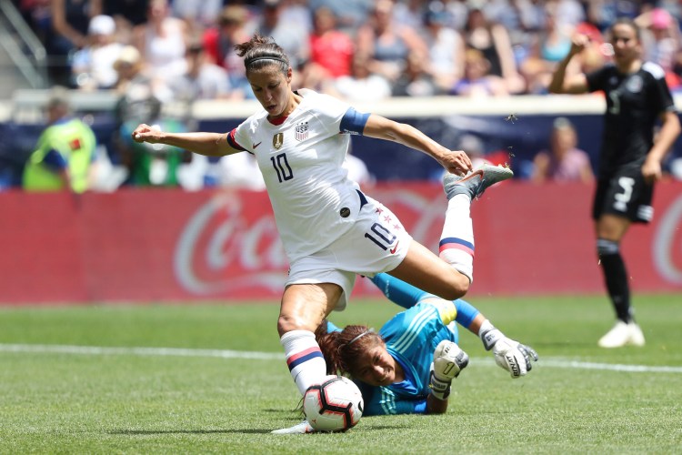 United States forward Carli Lloyd, center, dribbles past Mexico goalkeeper Cecilia Santiago to score a goal during the second half of an international friendly soccer match, Sunday, May 26, 2019, in Harrison, N.J. The U.S. won 3-0. (AP Photo/Steve Luciano)