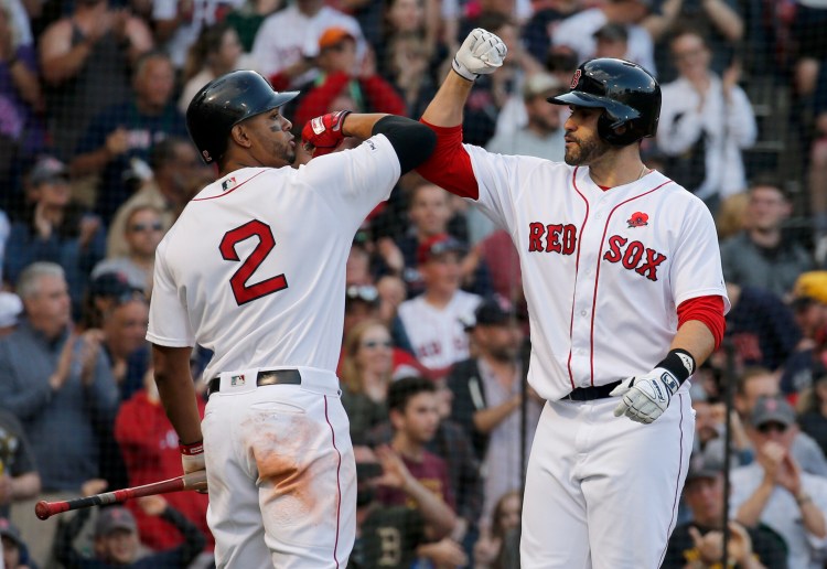J.D. Martinez is congratulated by Xander Bogaerts after hitting a solo home run in the sixth inning of Boston's 12-5 win over the Indians on Monday at Fenway Park in Boston. 