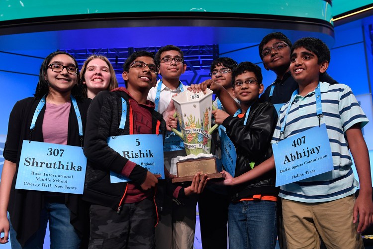 The eight co-champions of the 2019 Scripps National Spelling Bee, from left, Shruthika Padhy, 13, of Cherry Hill, N.J., Erin Howard, 14, of Huntsville, Ala., Rishik Gandhasri, 13, of San Jose, Calif., Christopher Serrao, 13, of Whitehouse Station, N.J., Saketh Sundar, 13, of Clarksville, Md., Sohum Sukhatankar, 13, of Dallas, Texas, Rohan Raja, 13, of Irving, Texas, and Abhijay Kodali, 12, of Flower Mound, Texas, hold the trophy at the end of the competition early Friday in Oxon Hill, Md.