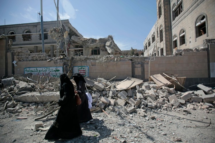 Yemenis walk past rubble after deadly airstrikes in and near the presidential compound, in Sanaa, Yemen, in 2018. Yemen's civil war started in 2014 when the Houthis overran the capital, Sanaa, and much of the country's north.