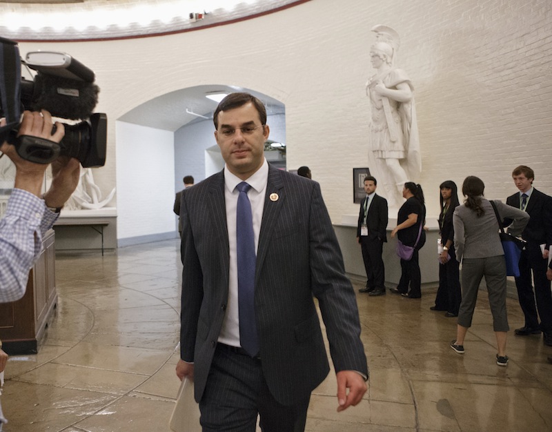Rep. Justin Amash, R-Mich., walks through a basement corridor to the House of Representatives for the vote on his amendment to the Defense spending bill that would cut funding to the National Security Agency's phone surveillance program, on Capitol Hill, Wednesday, July 24, 2013. The White House and congressional backers of the NSA's electronic surveillance program are warning that ending the massive collection of phone records from millions of Americans would put the nation at risk from another terrorist attack.  (AP Photo/J. Scott Applewhite)