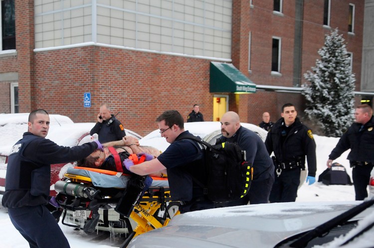 Firefighters and police escort Jason Begin after he was shot by Augusta police Officer Laura Drouin on Jan. 12, 2015, during a confrontation at an office at the Ballard Center — the former MaineGeneral Medical Center — in Augusta.