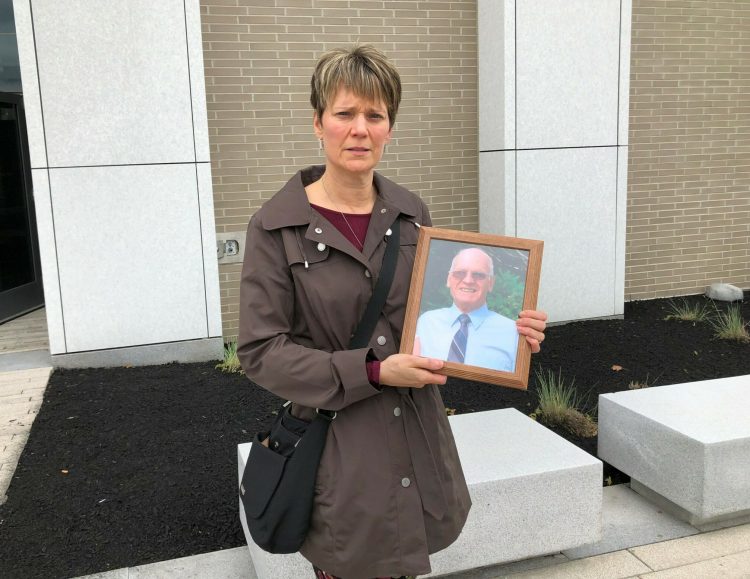 Caryn Murphy, daughter of the late Emile Morin, holds a photo of him that the family brought to court on Wednesday.