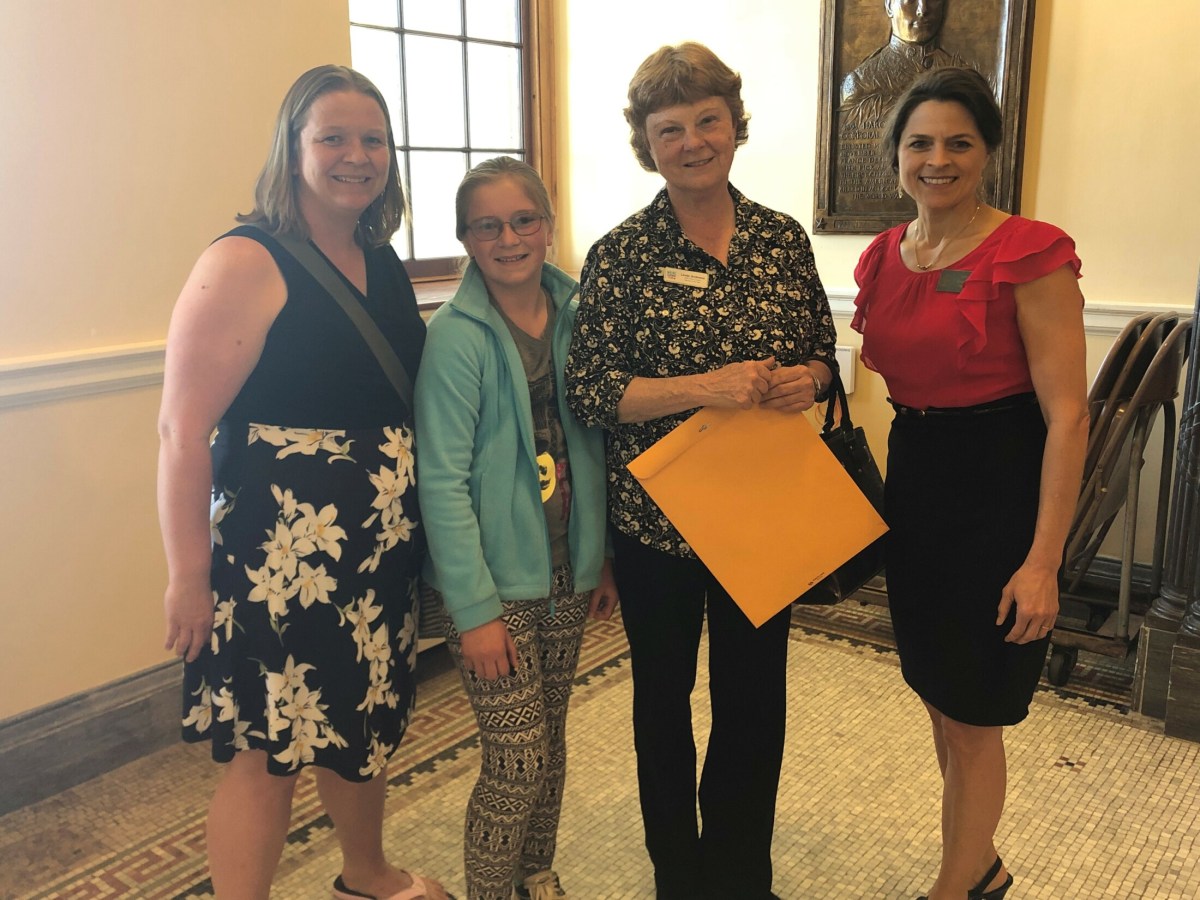Jess McGreevy and Charlotte McGreevy stand with Oxford County Teacher of the Year Linda Andrews, who received a legislative sentiment from Sen. Lisa Keim at the State House on May 9.