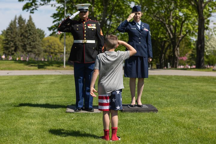 US Marine Ricky Harrington, of Oakland, left, and US Air Force Lorie Roy, of Waterville, right, stand at attention at the Maine Veterans Memorial Cemetery on this memorial day to honor their fallen soldiers. Harrington has been showing his respect on Memorial Day for the past eight years by standing at attention from 10 a.m. to 1 p.m. He brings a display of war memorabilia representing the Civil War to the present, some of which include boots that were worn on several different continents, dog tags from every branch of the service, moss from Parris Island and a WWI combat helmet from the founders of the Oakland American Legion. While he was standing there for a short time, a 7-year-old Kemden Hafford faced them to salute.