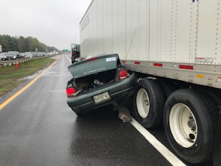 A woman escaped serious injury Friday morning when her car went underneath a tractor-trailer on the Maine Turnpike in Portland.
