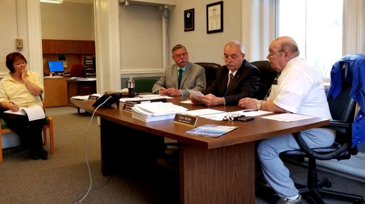 From left, county Finance Manager Vickie Braley looks on as Franklin County Commission Chairman Terry Brann, of Wilton; Charles Webster, of Farmington; and Clyde Barker, of Strong, discuss business at the Franklin County Courthouse in Farmington. 