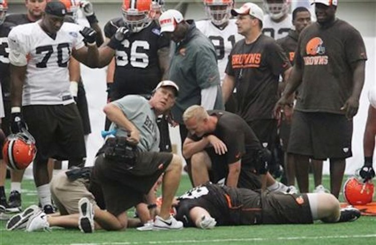 Cleveland Browns offensive lineman Ryan Miller is attended to by the team's medical staff after suffering a concussion in training camp in 2013. Today, the threat of brain injury is part of every conversation on football, from the NFL to youth football.