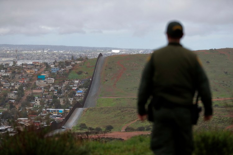 A U.S. border patrol officer overlooks the wall that separates the cities of Tijuana, Mexico, and San Diego.