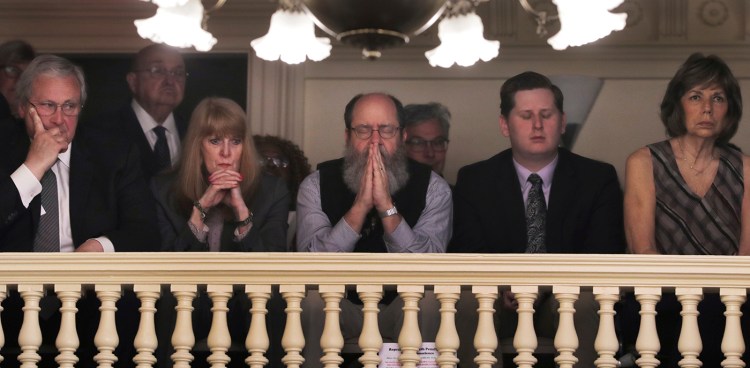 Rob Spencer, center, of Concord, N.H. pauses in prayer as legislators debate prior to a death penalty vote at the State House in Concord, N.H. on Thursday.