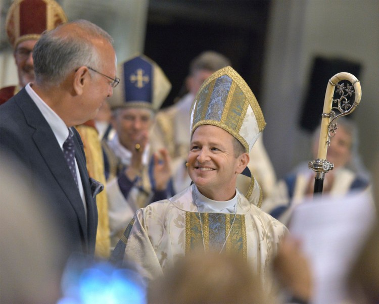 Bishop Thomas James Brown shares a smile with his husband, the Rev. Thomas Mousin at the end of his ordination ceremony in June 2019.