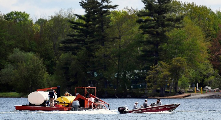 A barge from SOLitude Lake Management, left, spreads alum June 3 on Cochnewagon Lake in Monmouth as Cobbossee Watershed District workers test the water. 