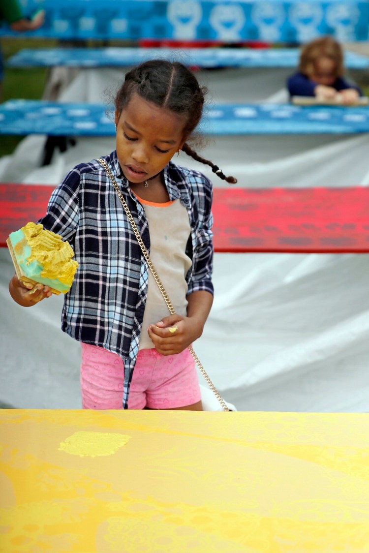 Jaiden Johnson, 9, of Portland removes a sponge to reveal a painted pattern during a TEMPOart event, led by Portland artist Daniel Minter in early June in Kennedy Park. The completed works will be part of a public art installation, Mother's Garden, beginning June 15 that link food, culture and art.