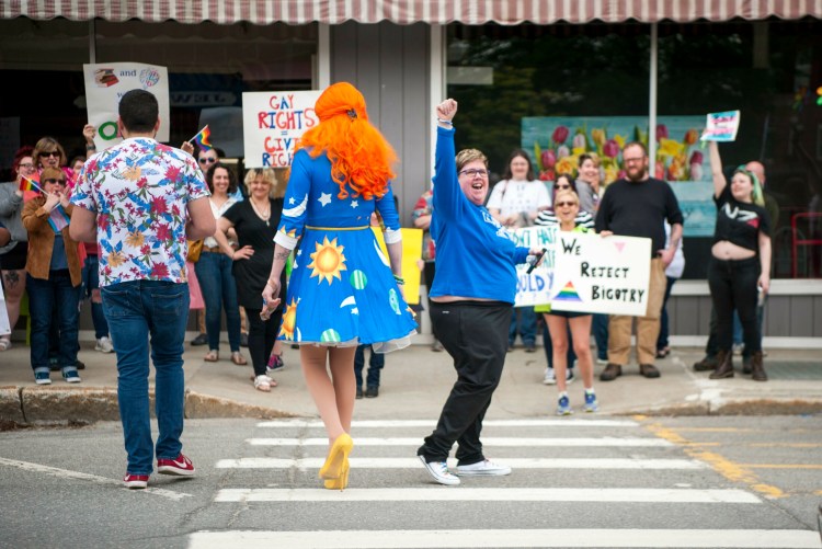 Ophelia, a drag queen, crosses Main Street toward a group of activist promoting equality Saturday at the Children's Book Cellar in Waterville.