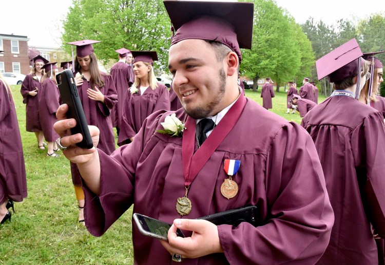 Maine Central Institute senior Nathan Torres used three cellphones to photograph fellow graduates before  the school's 150th commencement Sunday in Pittsfield.