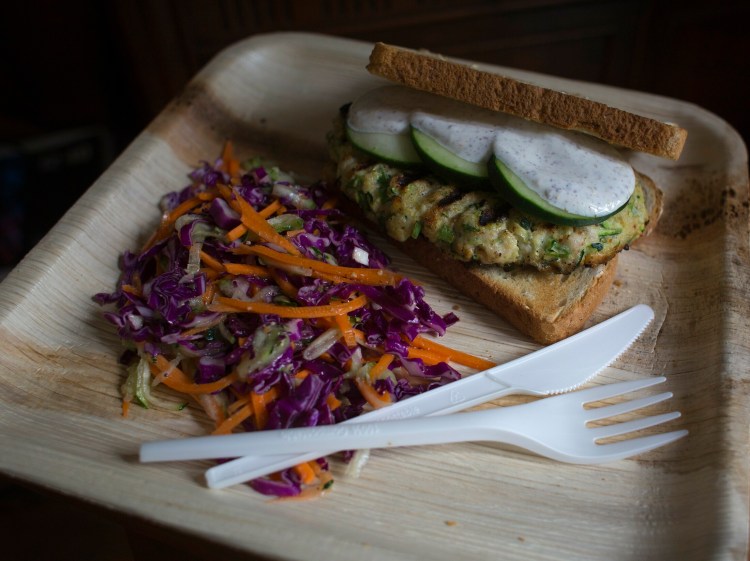 A chicken-zucchini burger on a bamboo plate. What are the greenest options for disposable dishware?