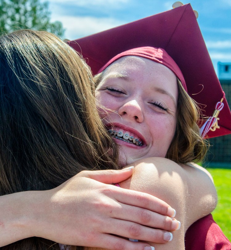 Hannah Moholland gets a hug in the reception line after Richmond High School graduation Saturday outside the school in Richmond.