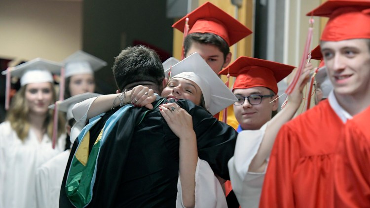 Cony High School teacher Jason Morgans hugs every graduate he can Sunday before marching into graduation ceremonies in Augusta.