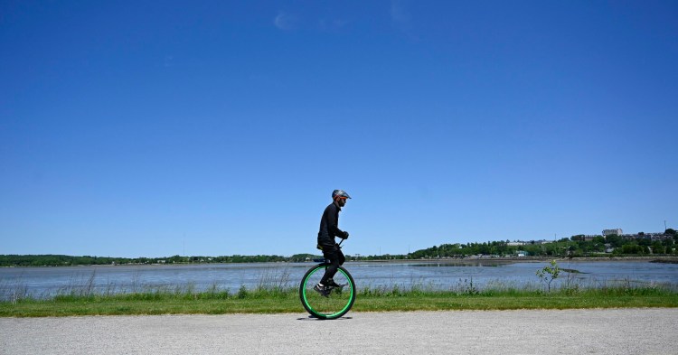 Hugh Sharp, the first person to complete the 180-mile Trek Across Maine on a unicycle, rides on Portland's Back Cove Trail on Wednesday.