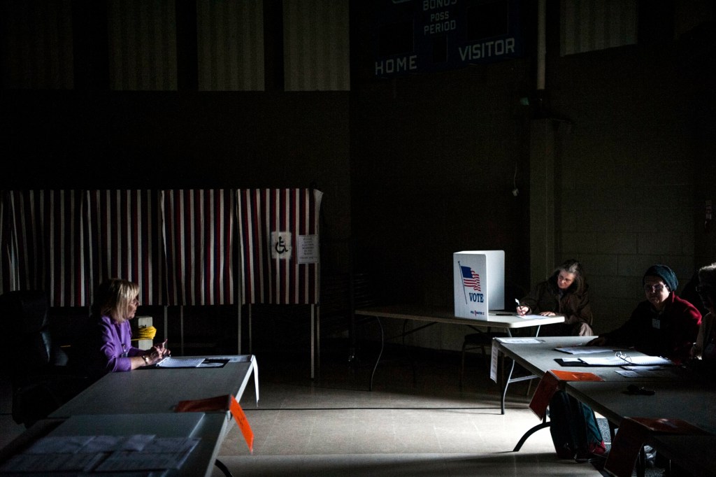 Volunteers and voters work in the dark to cast ballots after a power outage at a voting station at the Fairfield Community Building in Fairfield on Tuesday.  The SAD 49 school district budget was on the ballot.