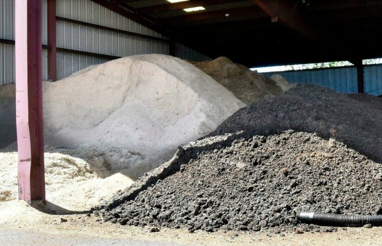 Sawdust, at left, and sewer sludge are piled in a storage barn off the Notch Road in Skowhegan on Monday. The elements are mixed together and used as fertilizer. Skowhegan has tested its mix and received approval for land use.