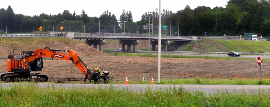 Workers attend to a feller buncher Thursday on the southbound on-ramp to Interstate 95 off Western Avenue in Augusta. the Maine DOT recently cleared all the trees between the exit and on ramps at Exit 109.