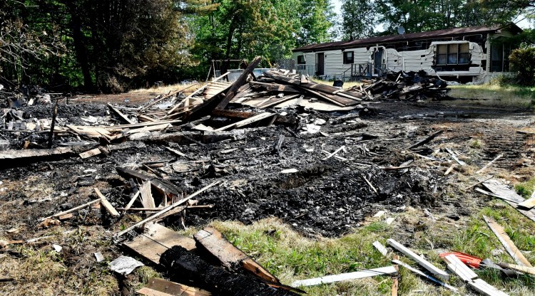 On Tuesday, a pile of burned wood and home furnishings is all that remains of a home along U.S. Route 2 in Palmyra that was destroyed by fire Sunday. 