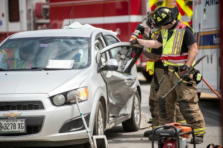 Waterville firefighters extract Alexis Hewey, 23, from her car after it and another car collided Tuesday on College Avenue in Waterville.