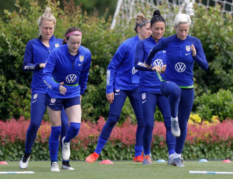 US player Megan Rapinoe, front right, stretches with Ali Krieger and other team members during a US womens soccer team training session at the Tottenham Hotspur training centre in London, Thursday, June 6, 2019. The Women's World Cup starts in France on June 7. (AP Photo/Kirsty Wigglesworth)