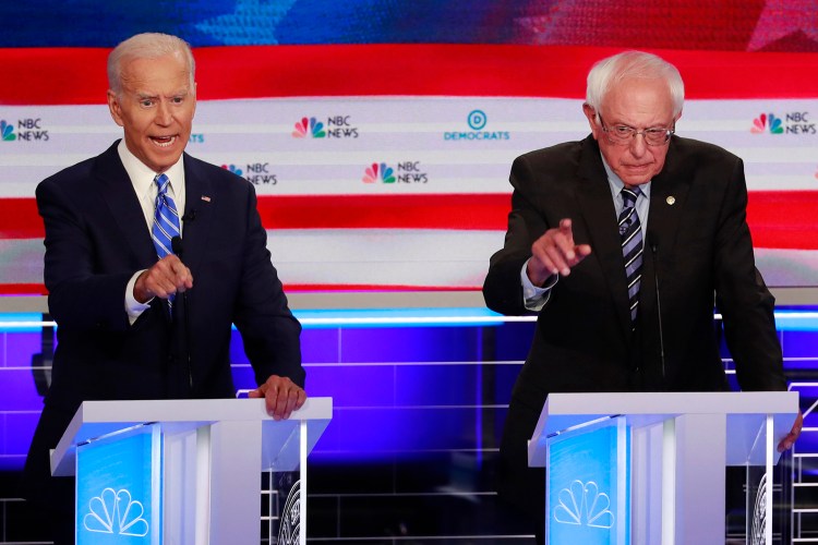 Former Vice President Joe Biden, left, and Sen. Bernie Sanders, I-Vt., speak at the same time during Thursday night's Democratic debate  in Miami. The raucous debate highlighted the deep ideological divisions among the Democratic candidates.