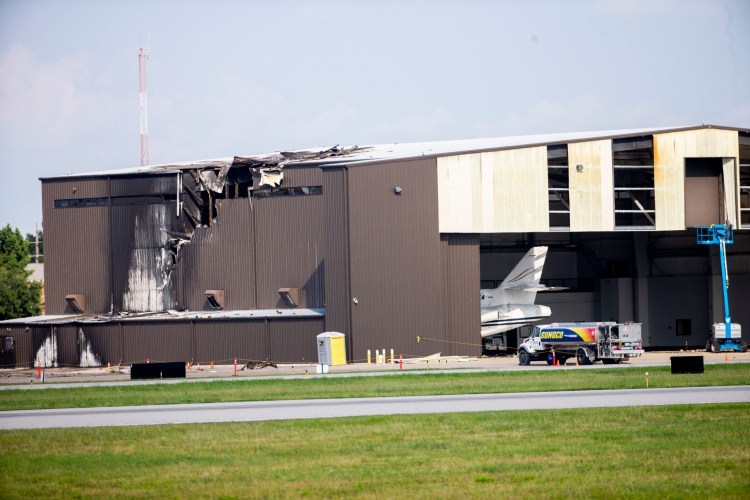 A hangar shows damage after a twin-engine plane crashed into it at Addison Airport in Addison, Texas, on Sunday.
