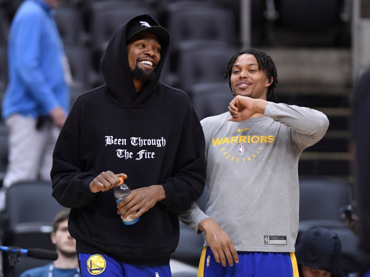 Golden State Warriors Kevin Durant, left, laughs with teammate Damion Lee during practice Saturday in Toronto, Saturday. The Warriors hope Durant will be available for Game 5 on Monday.
