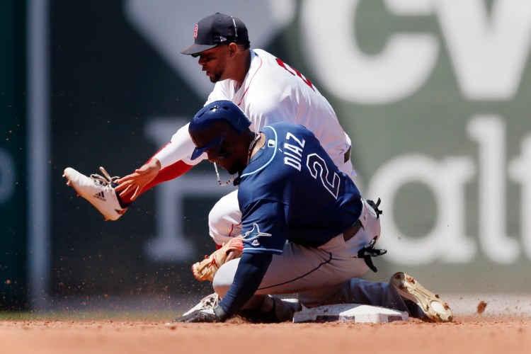 Tampa Bay's Yandy Diaz slides into Red Sox's shortstop Xander Bogaerts but is called out on the play trying to stretch a single into a double during the Rays' 9-2 win in the first game of a doubleheader Saturday at Fenway Park in Boston.  
