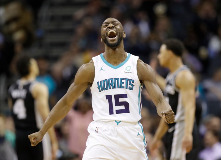 FILE - In this March 26, 2019, file photo, Charlotte Hornets' Kemba Walker (15) reacts after making a basket against the San Antonio Spurs during the second half of an NBA basketball game in Charlotte, N.C. The three-time All-Star point says he’d be willing to work with the Hornets and take less than the “supermax” $221 million contract he’s eligible to receive to re-sign with Charlotte (AP Photo/Chuck Burton, File)