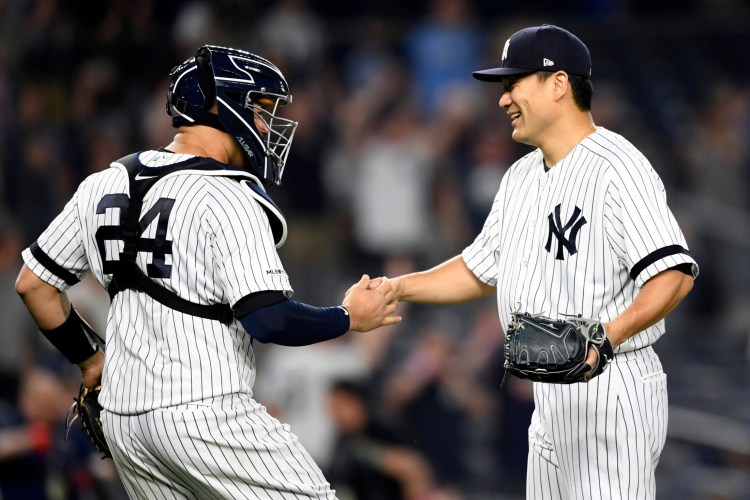 Yankees starter Masahiro Tanaka, right, celebrates with catcher Gary Sanchez after pitching a shutout in New York's 3-0 win over Tampa Bay on Monday in New York.