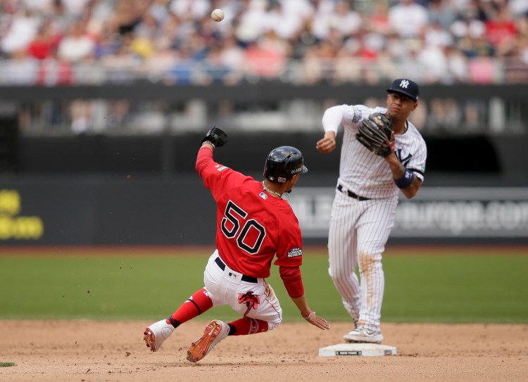 Boston Red Sox's Mookie Betts, left, is forced out at second by New York Yankees second baseman Gleyber Torres after Xander Bogaerts hit into a double play during the fifth inning of a baseball game in London, Sunday, June 30, 2019. (AP Photo/Tim Ireland)