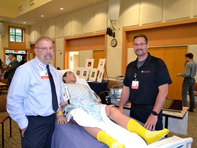 Franklin Memorial Hospital employees Bertrand Dugal and Michael Senecal flank a patient simulator used for a demonstration.