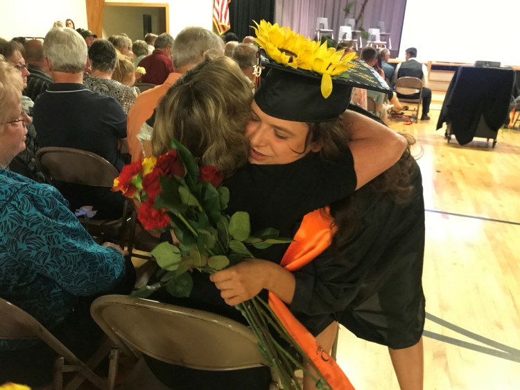 Hannah Harmon, a 2019 graduate of Forest Hills Consolidated School, gives a flower to her former art teacher in another district and friend Susan Beaulier during commencement Saturday.