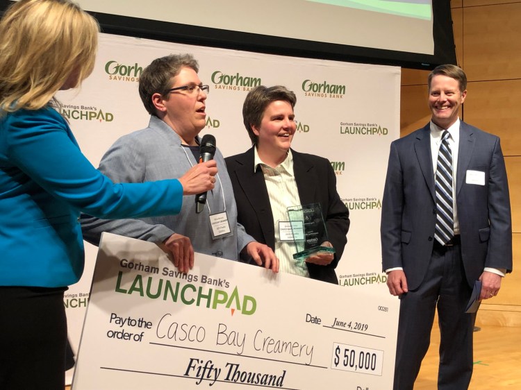 Michelle Neujahr, left, presents the 2019 LaunchPad award of $50,000 to Casco Bay Creamery co-founders Alicia Menard and Jennell Carter while Gorham Savings Bank President and CEO Steve deCastro looks on.