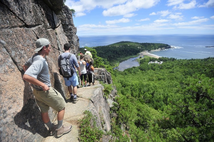 A line of hikers files up the Beehive Trail in  Acadia National Park in 2013 (but displaying some social distancing).