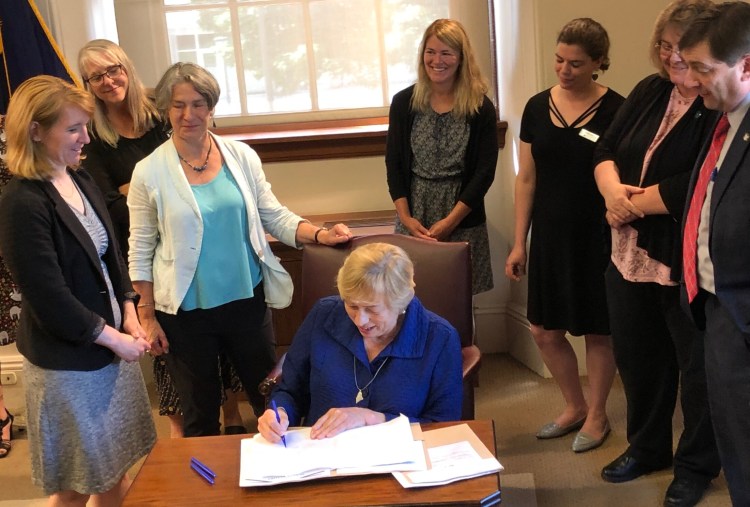 Gov. Janet Mills signs bills aimed at lowering drug prices and increasing industry transparency as state lawmakers and advocates for prescription drug price reform gather in the Cabinet room at the State House on Monday.