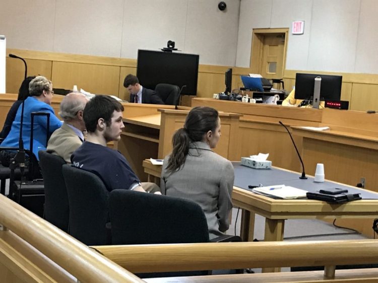 Dominic Sylvester, center, appears in West Bath District Court between his attorneys in June 2019. He is charged with depraved indifference murder in the death of his grandmother in February 2018. 