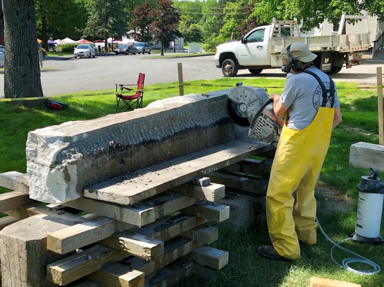 Sculptor Jon Doody uses a demolition saw to remove material from a block of granite Saturday that he plans to turn into a sturgeon at Stevens Commons in Hallowell. 