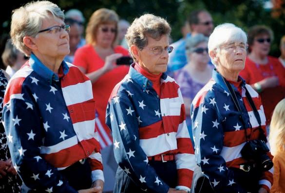 The Freeport Flag Ladies, from left, Elaine Greene, Carmen Footer and JoAnn Miller, listen at a 2013 ceremony marking the anniversary of Sept. 11, 2001.